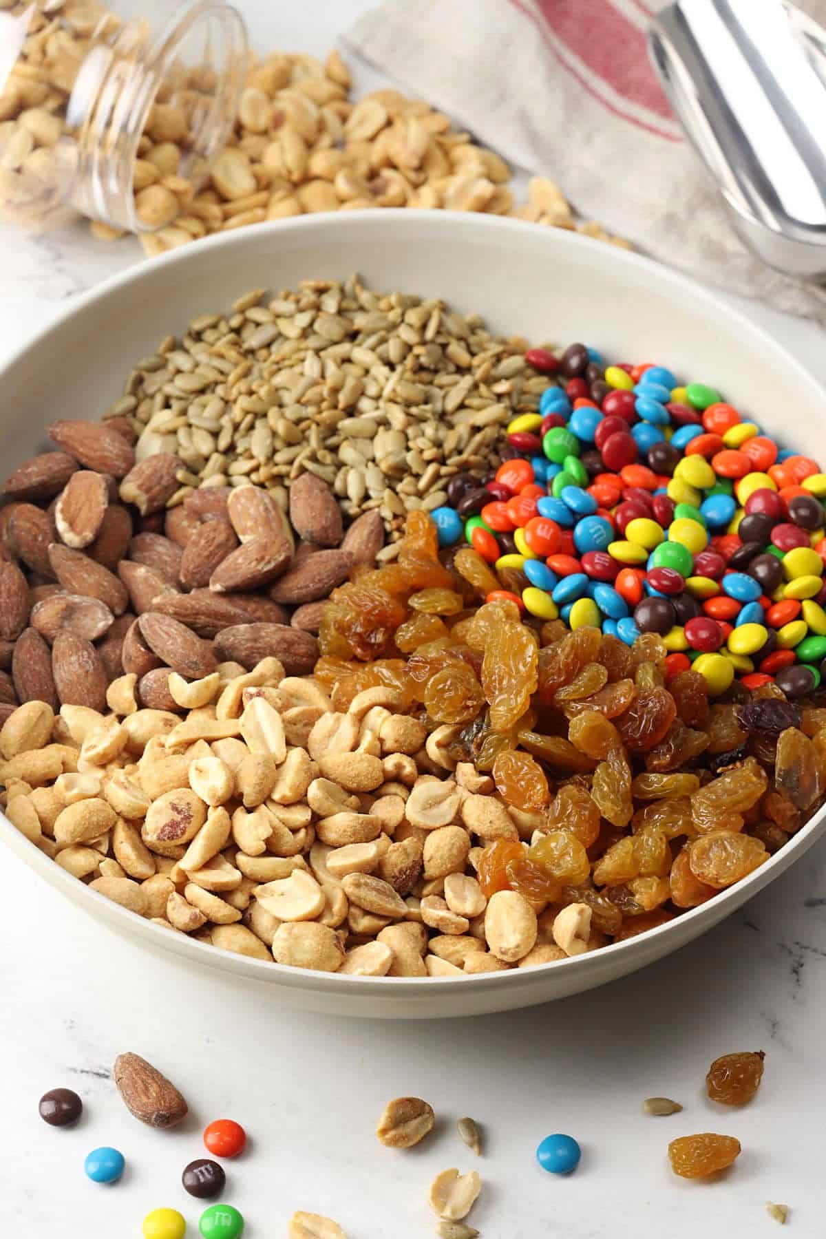 Cream colored bowl filled with trail mix ingredients.