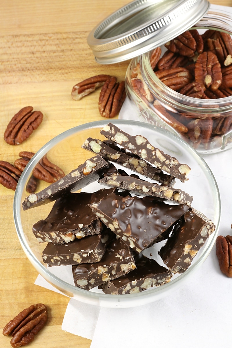 A glass bowl filled with chocolate pecan toffee bark.
