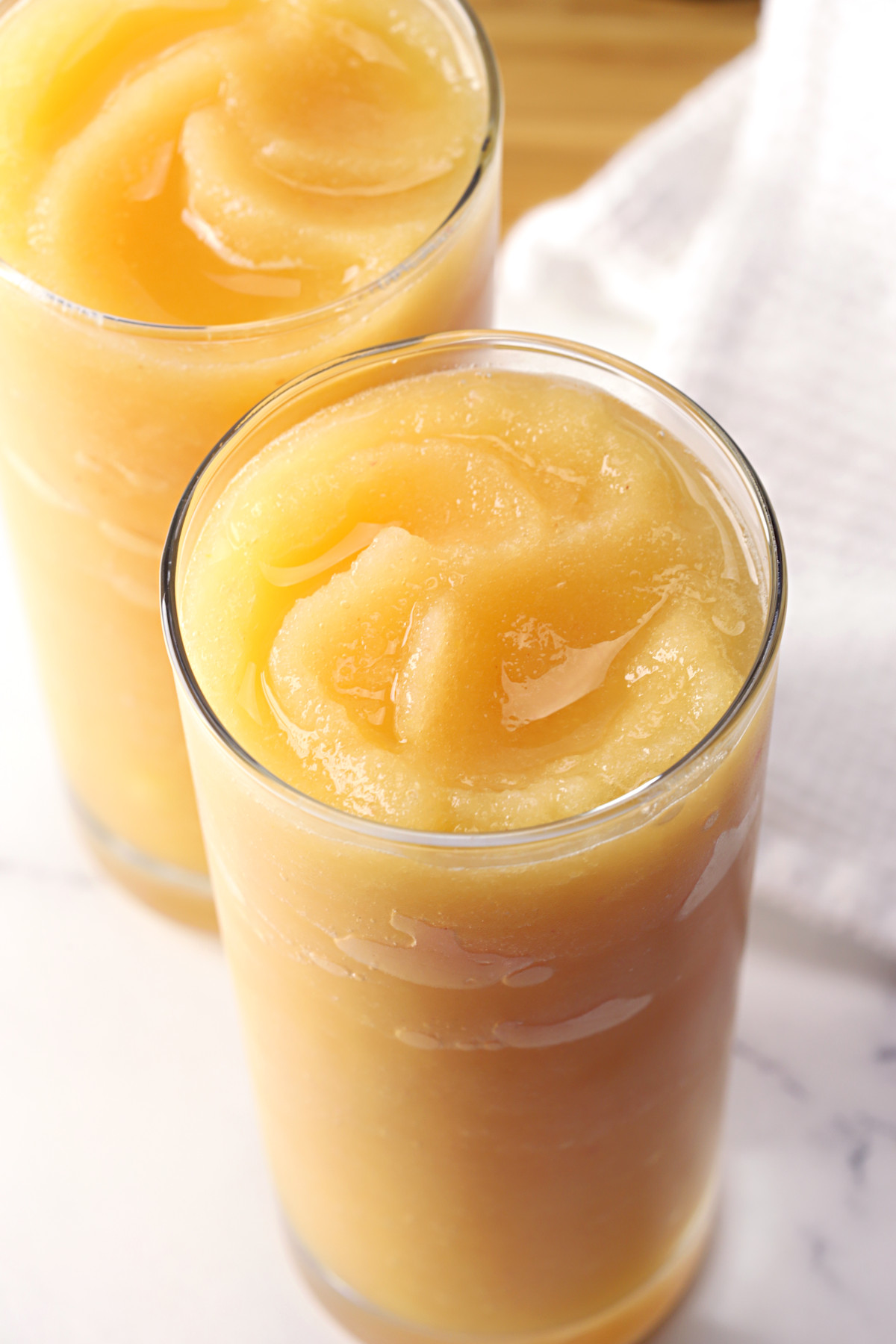 Ginger peach vodka slush swirled in a glass.