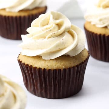 Applesauce cupcake in a brown paper wrapped topped with brown butter frosting.
