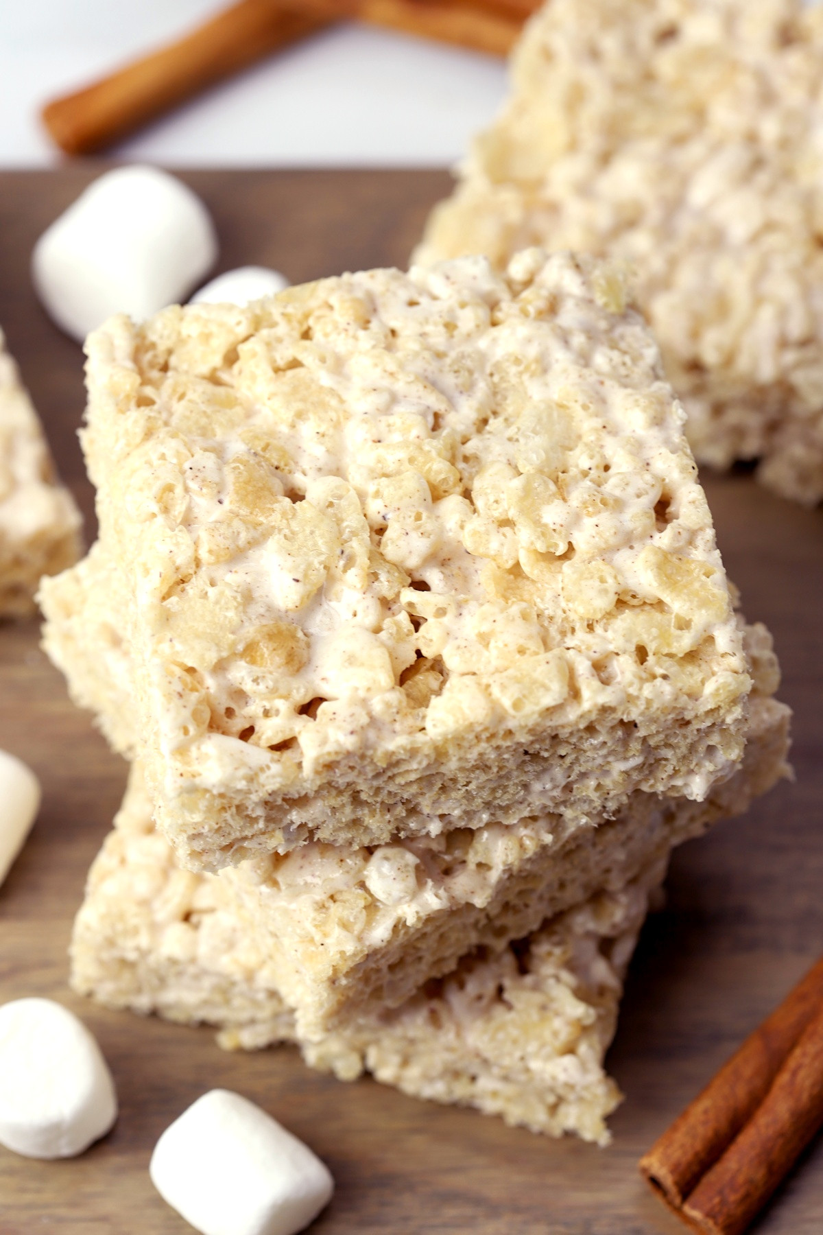 A stack of rice krispies treats with marshmallows and cinnamon sticks.