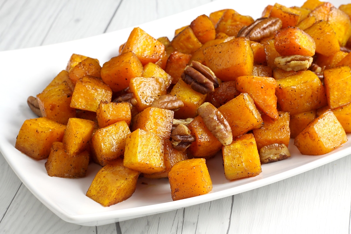 Roasted butternut squash and pecans on a serving plate.