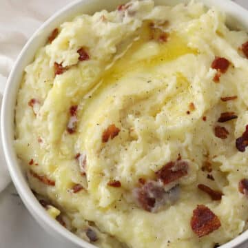 Bacon garlic mashed potatoes with melting butter on top.