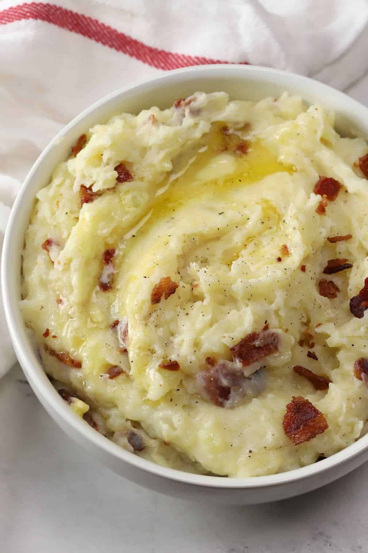 Bacon garlic mashed potatoes with melting butter on top.