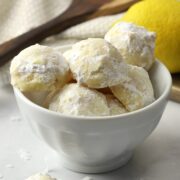 A white bowl filled with snowball cookies.