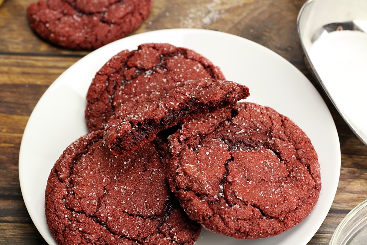 A red velvet cookie broken in half to show soft interior.