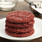 A stack of red cookies on a white plate.