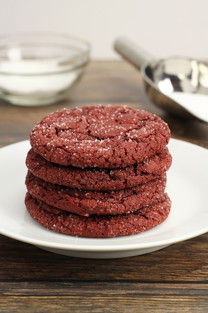 A stack of red cookies on a white plate.