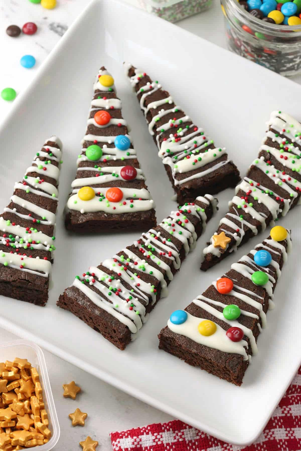 Square white plate filled with Christmas tree brownies.