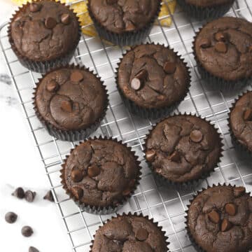 Chocolate muffins on a metal cooling rack.
