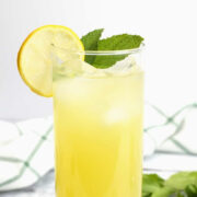 A tall glass of lemonade with a mint sprig.