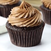 A chocolate cupcake topped with piped chocolate frosting.