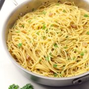 Spaghetti topped with sauteed garlic and chopped parsley.