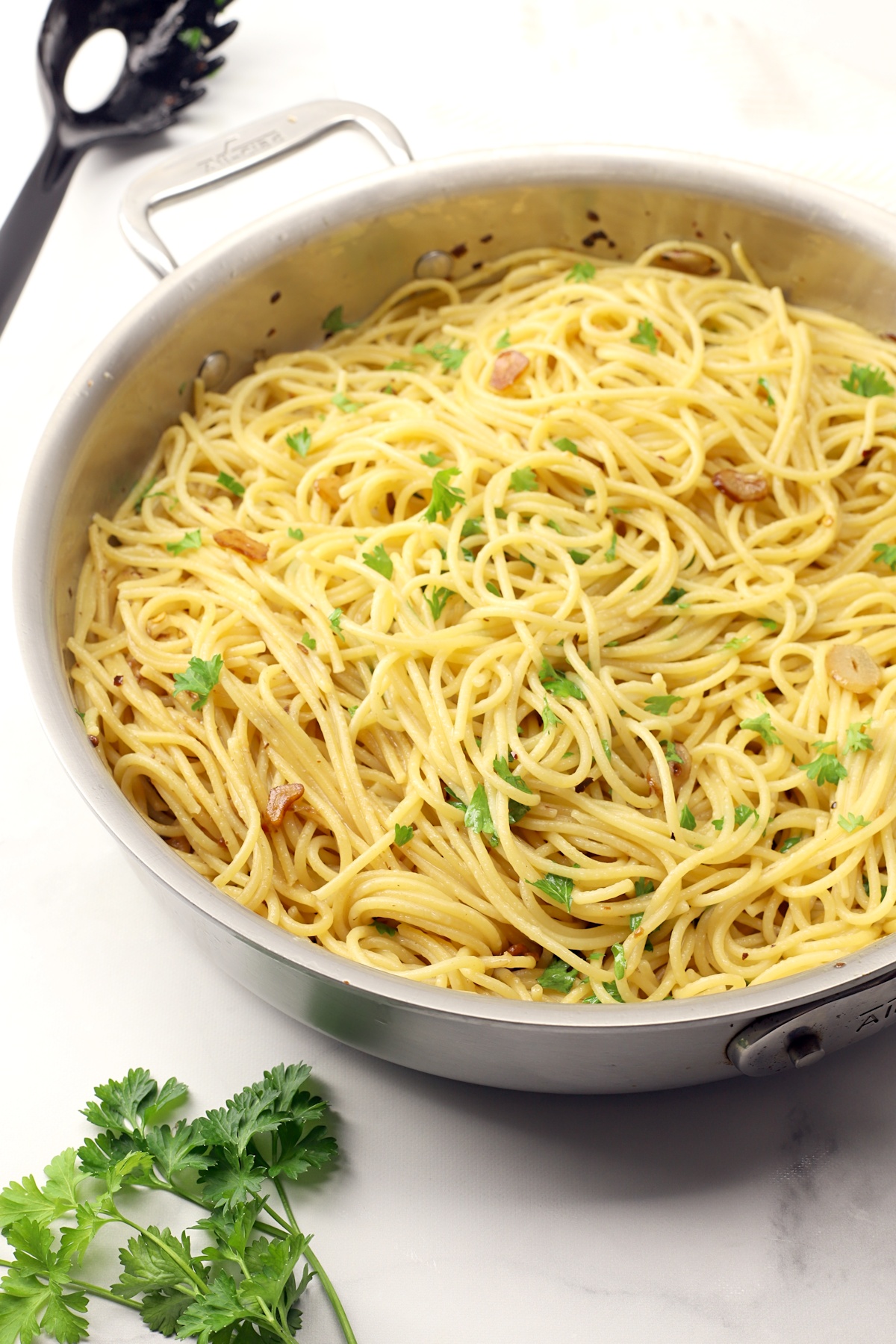 Spaghetti topped with sauteed garlic and chopped parsley.