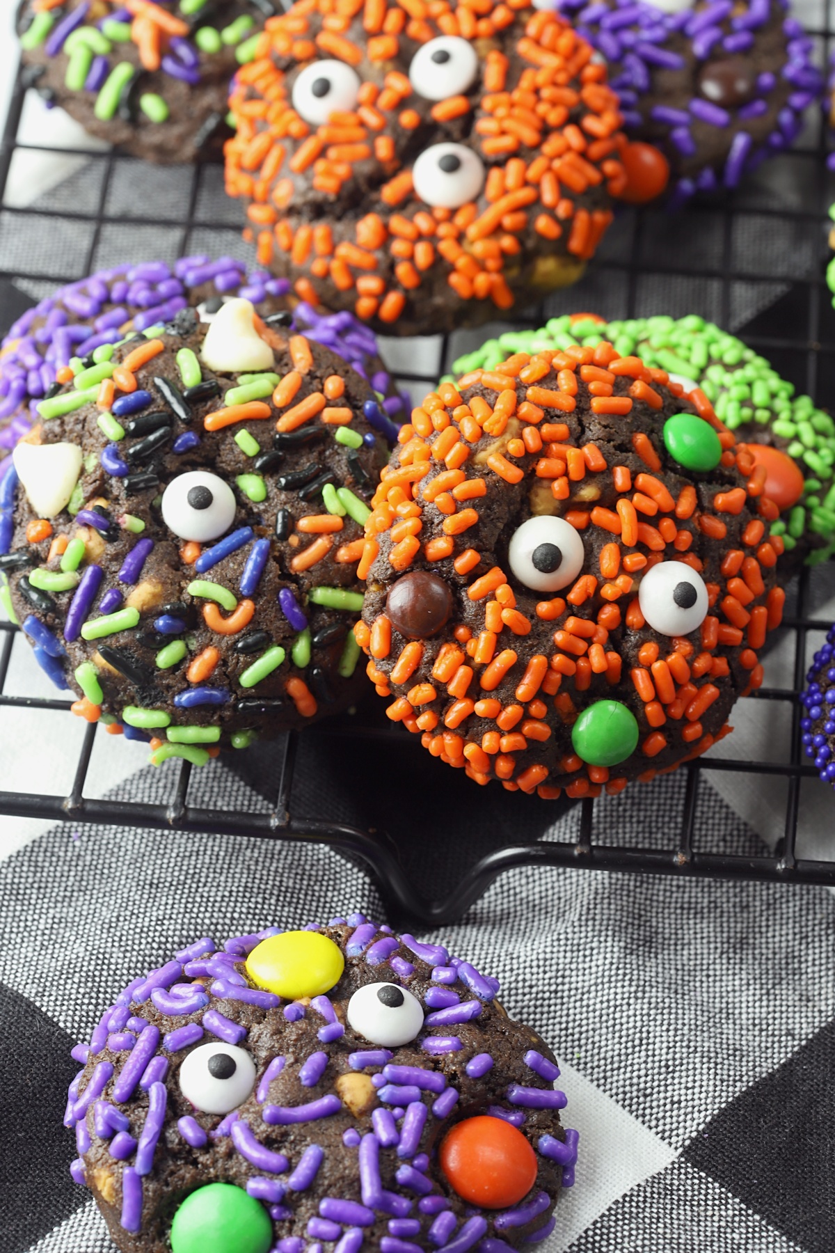 Chocolate cookies covered with sprinkles, candy eyeballs, and m&m candies.