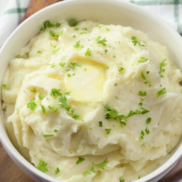 A white bowl filled with mashed potatoes.