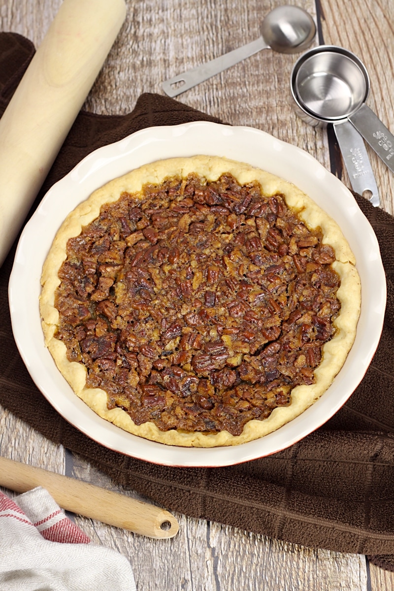 White pie pan filled with homemade pecan pie.