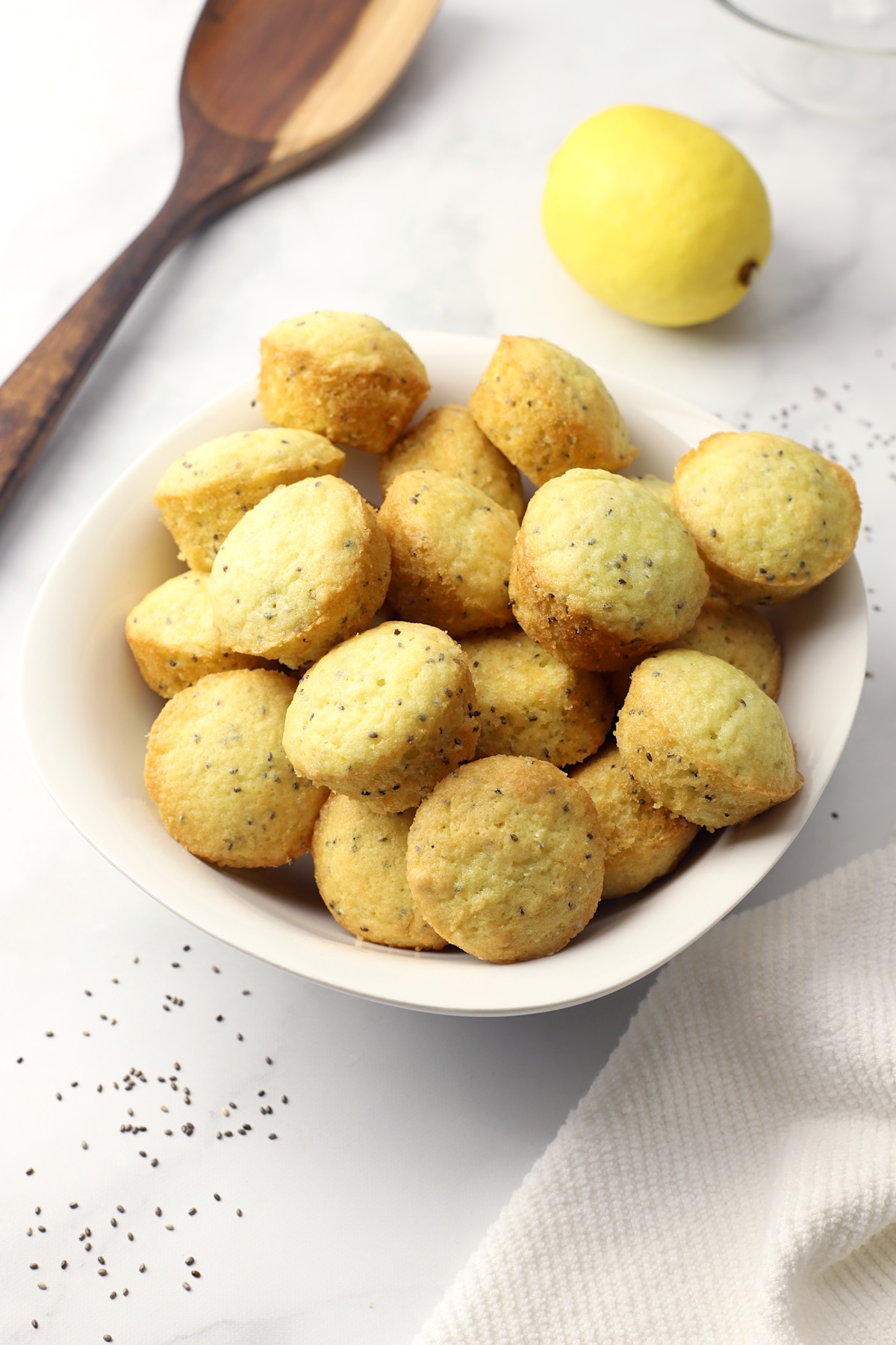 A white bowl filled with muffins.