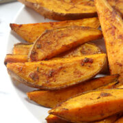 Sweet potato wedges on a white plate.