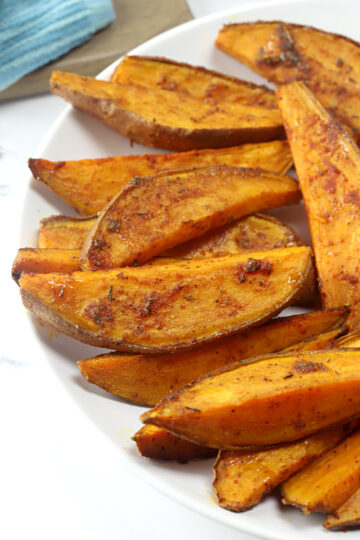 Sweet potato wedges on a white plate.