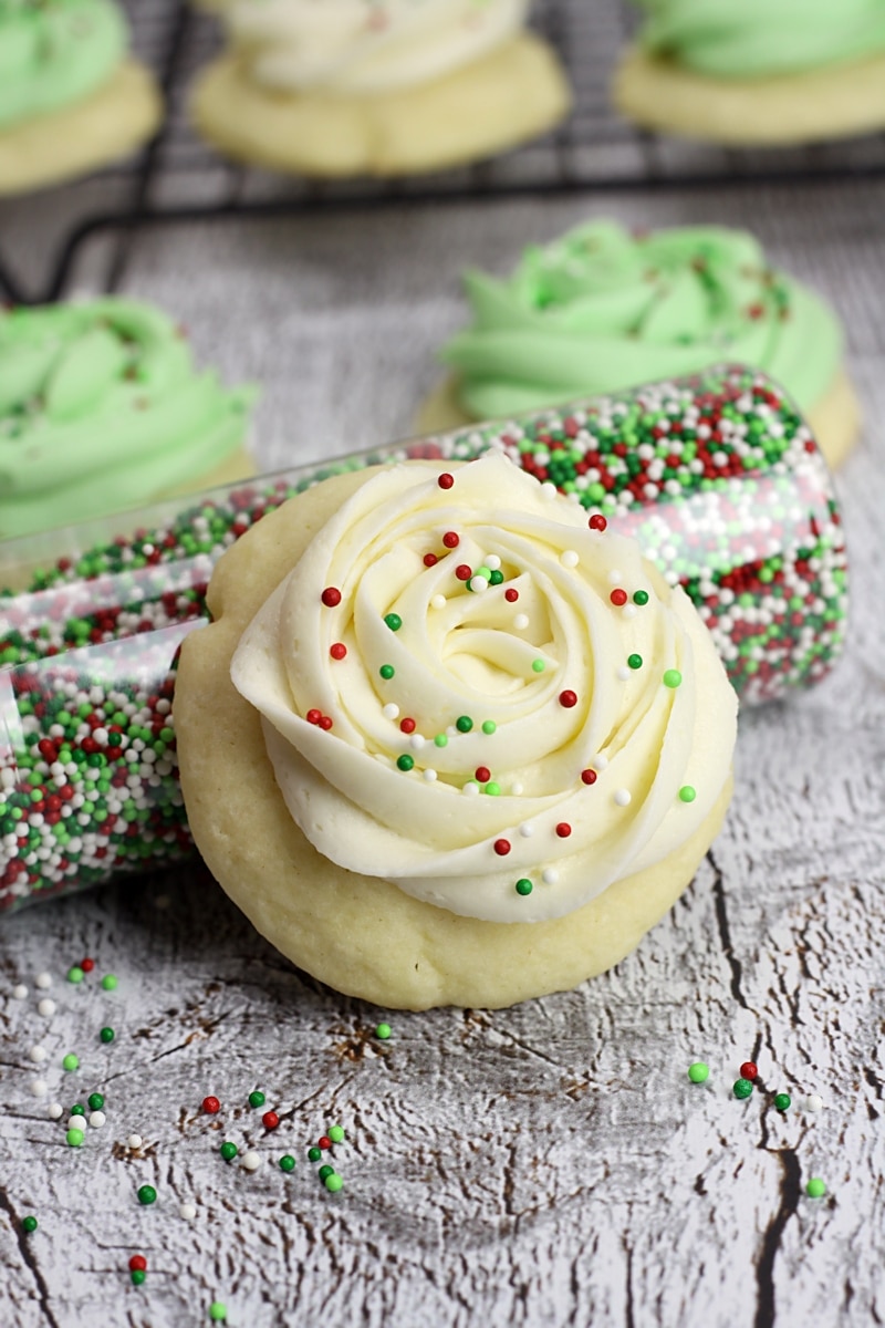 Frosted sugar cookie with red and green sprinkles on top.