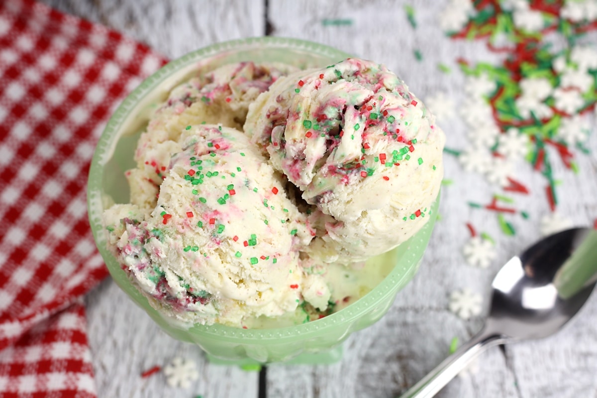 Red and green sprinkles on top of a bowl of ice cream.
