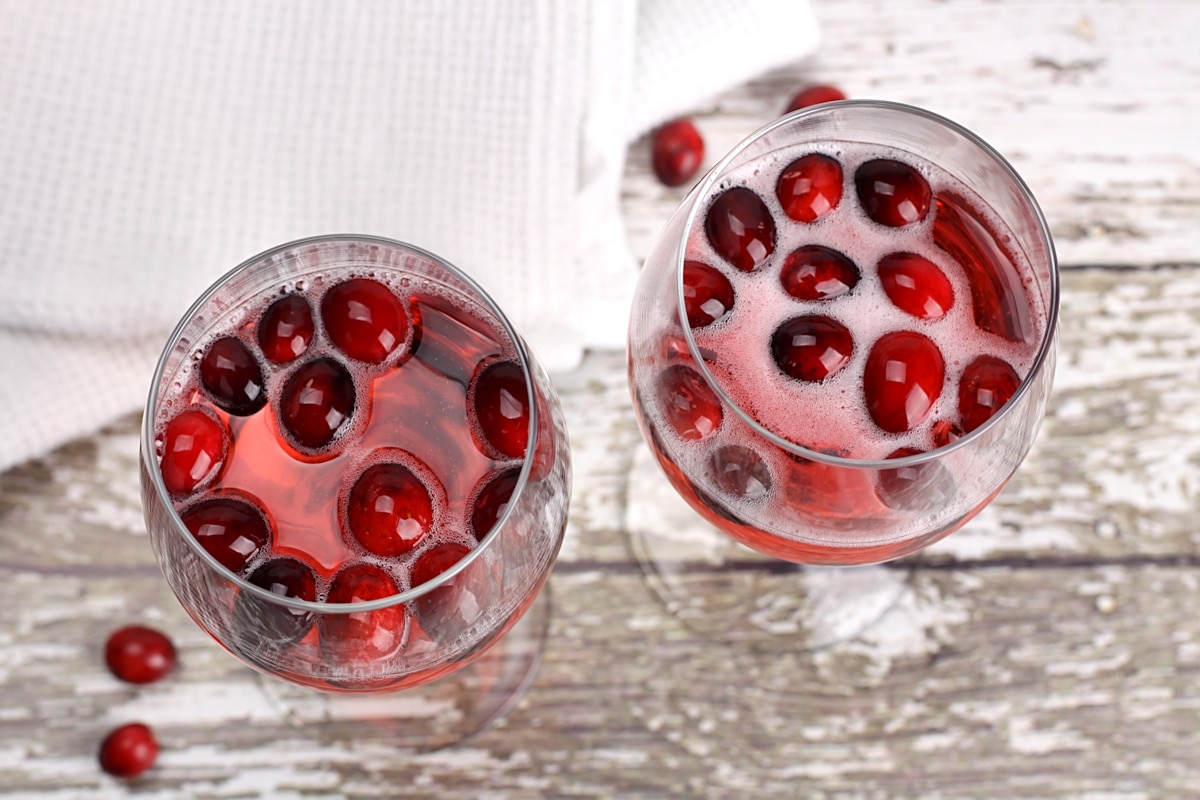 Cranberries floating to the top of wine glasses.