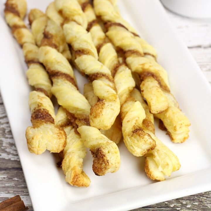 A white serving plate filled with puff pastry twists.