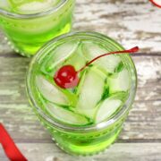 Green cocktail with a cherry on top.