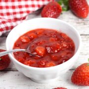 A white bowl filled with strawberry cheesecake topping.