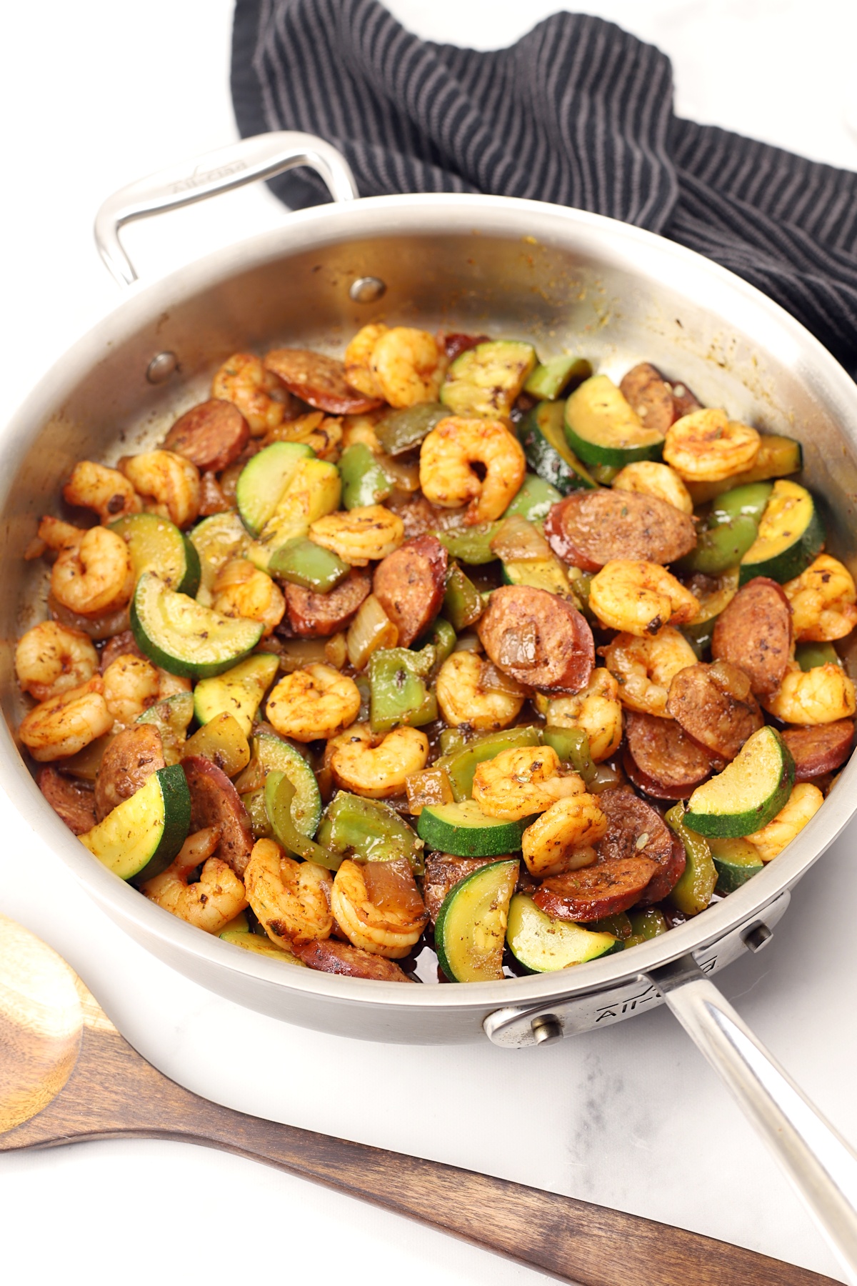A saute pan filled with shrimp, sausage, and veggies.
