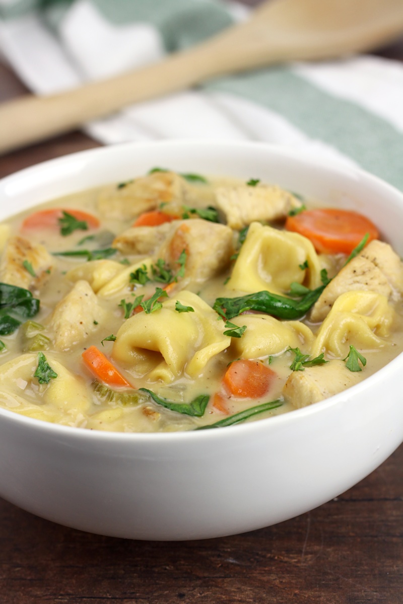 Un bol blanco lleno de sopa de tortellini.