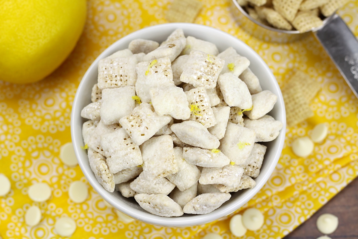 White bowl filled with puppy chow on a yellow napkin.