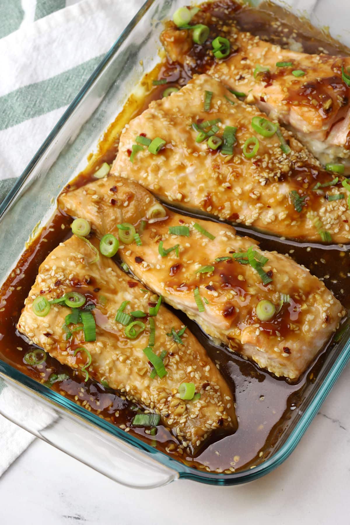 Baked teriyaki salmon in a glass casserole dish.