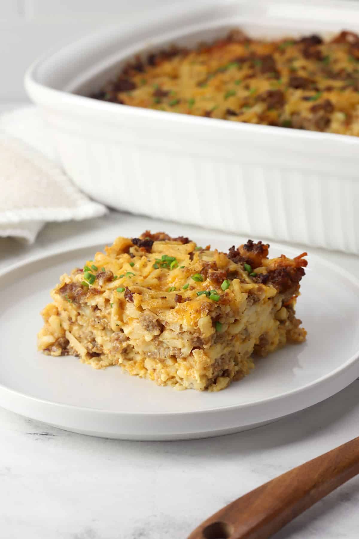 A slice of hash brown breakfast casserole on a serving plate.