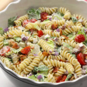 Scalloped edge bowl filled with BLT pasta salad.