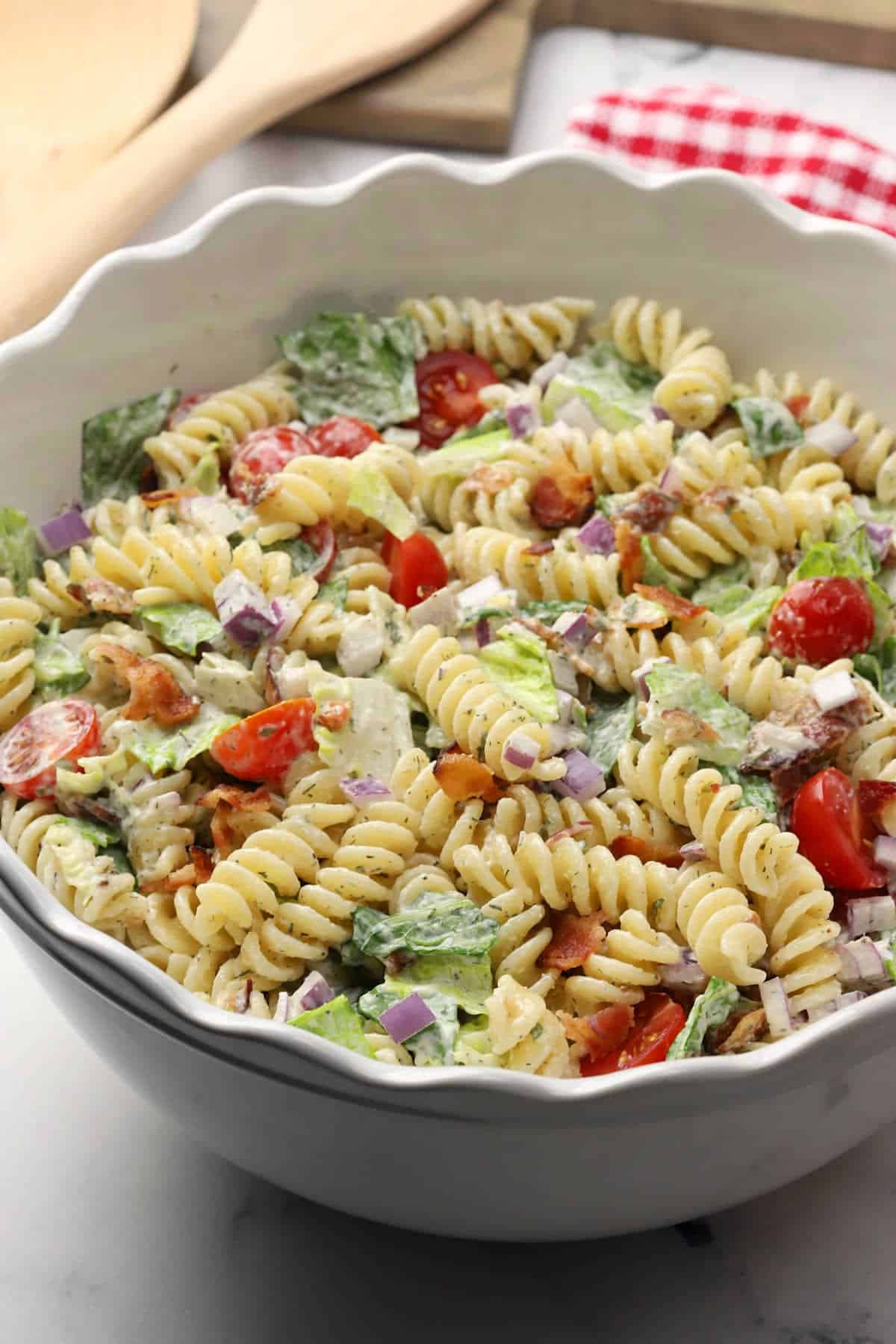 Scalloped edge bowl filled with BLT pasta salad.