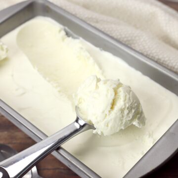 Vanilla ice cream being scooped by an ice cream scoop.