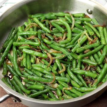 Green beans and onions in a saute pan.