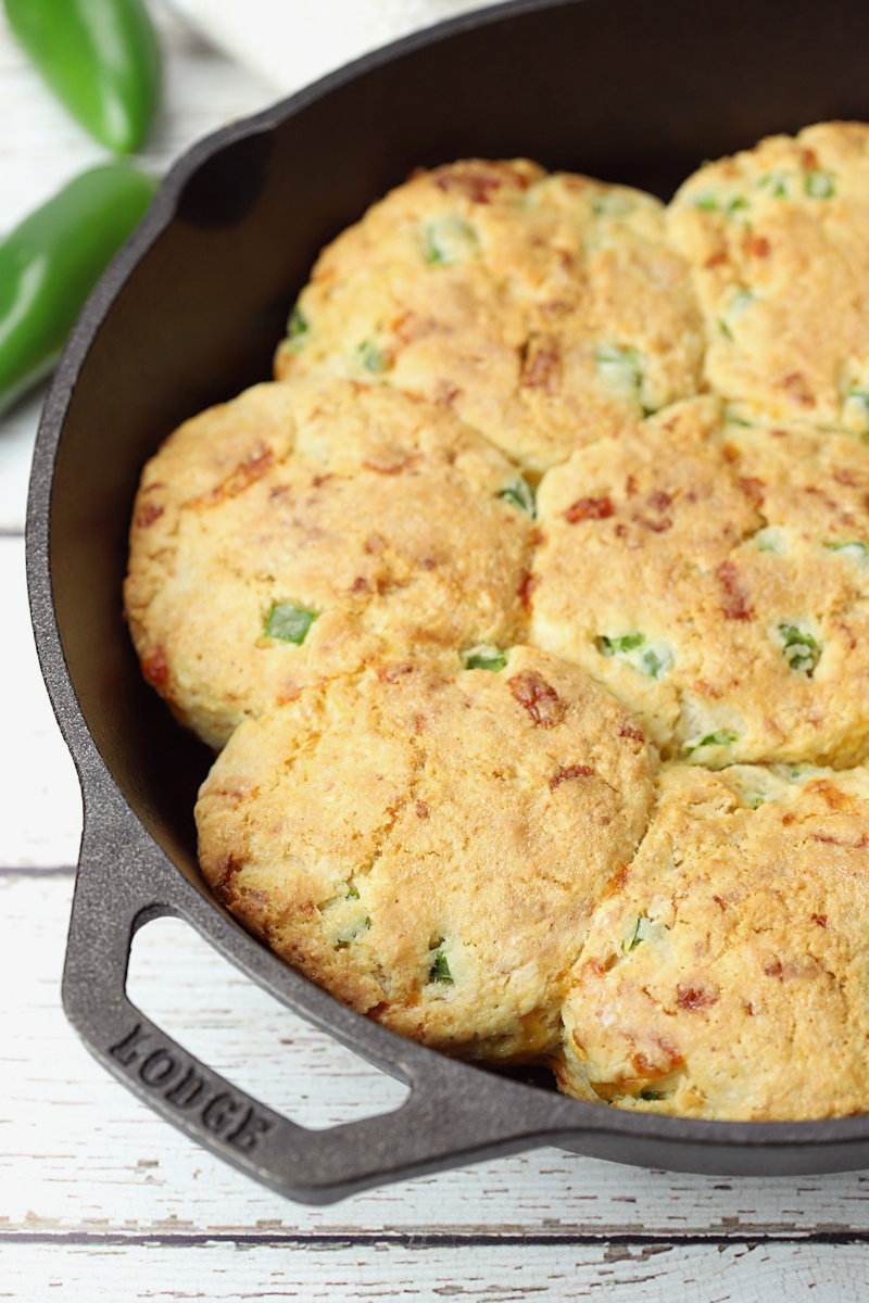 Close up of jalapeno cheddar biscuits baked in a cast iron skillet.