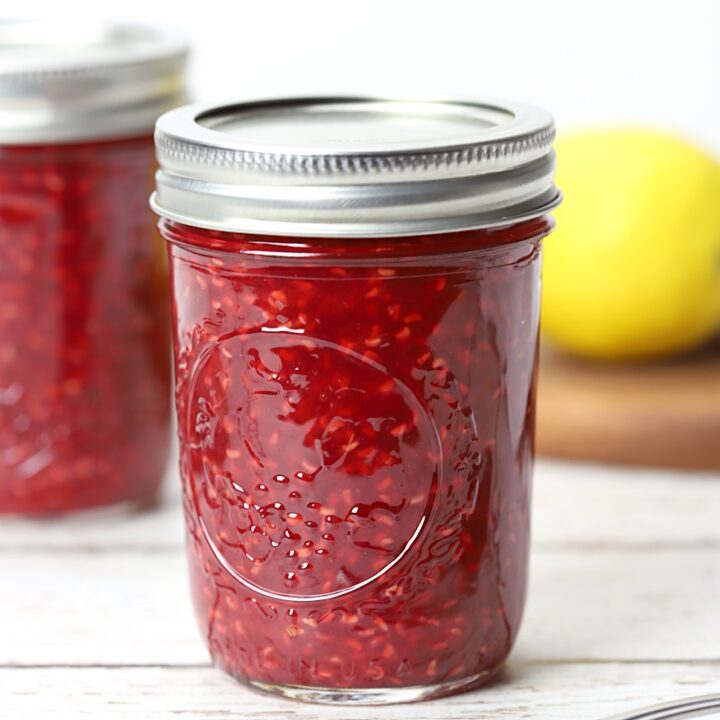 8 ounce jar filled with raspberry jam.