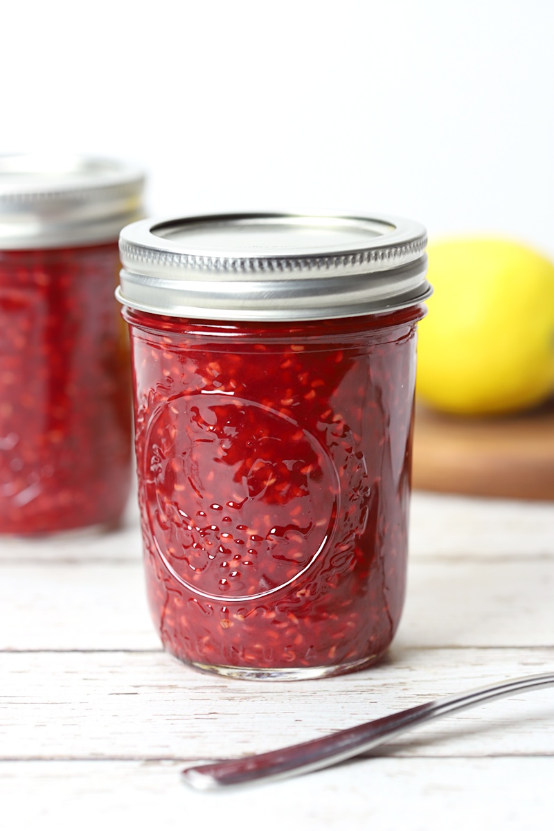 8 ounce jar filled with raspberry jam.