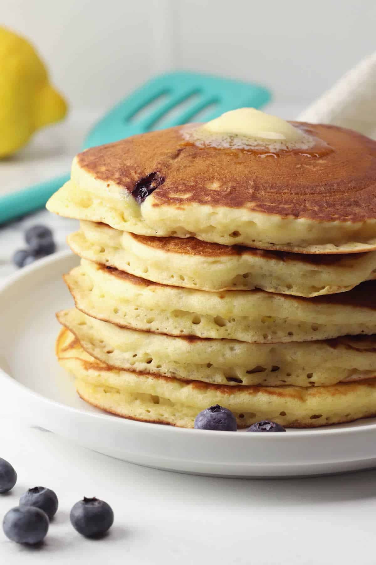 A stack of blueberry buttermilk pancakes on a white plate.