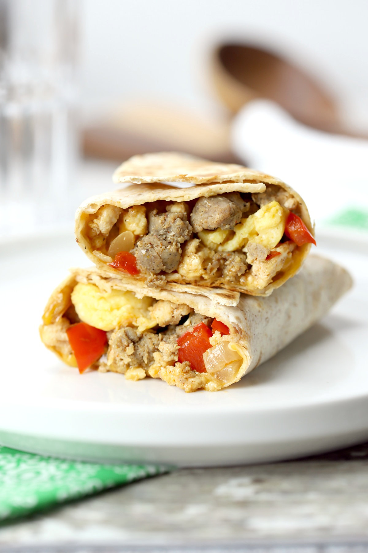 Breakfast burrito on a white plate, with a green napkin.