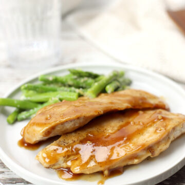 A plate of maple glazed chicken with asparagus.