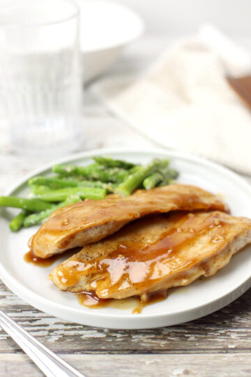 A plate of maple glazed chicken with asparagus.