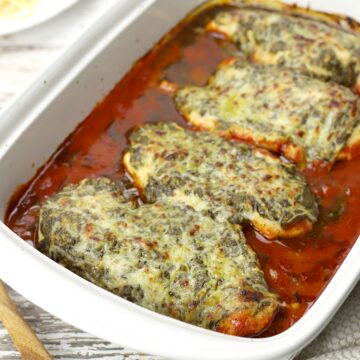 Pesto mozzarella chicken with marinara sauce in a large baking dish.