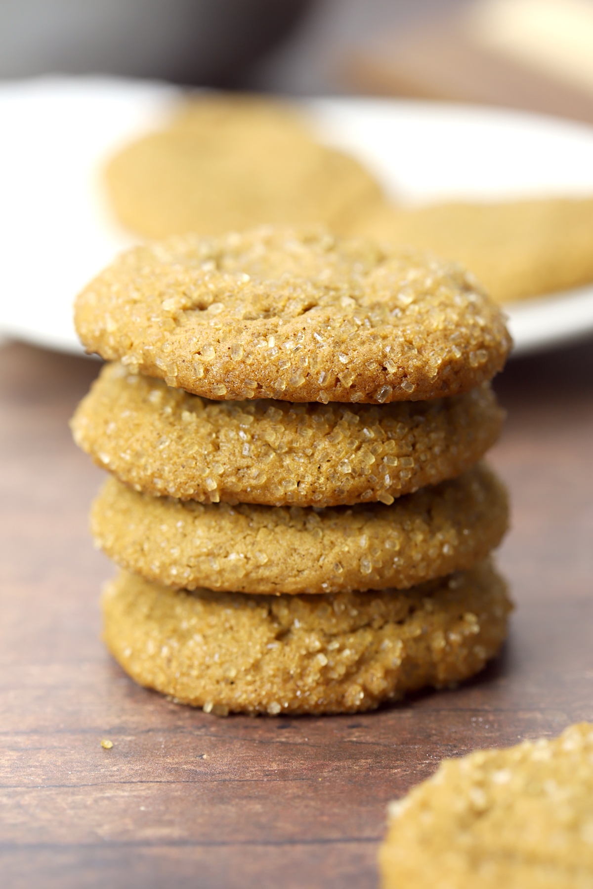 Stack of molasses cookies on a wood counter top.