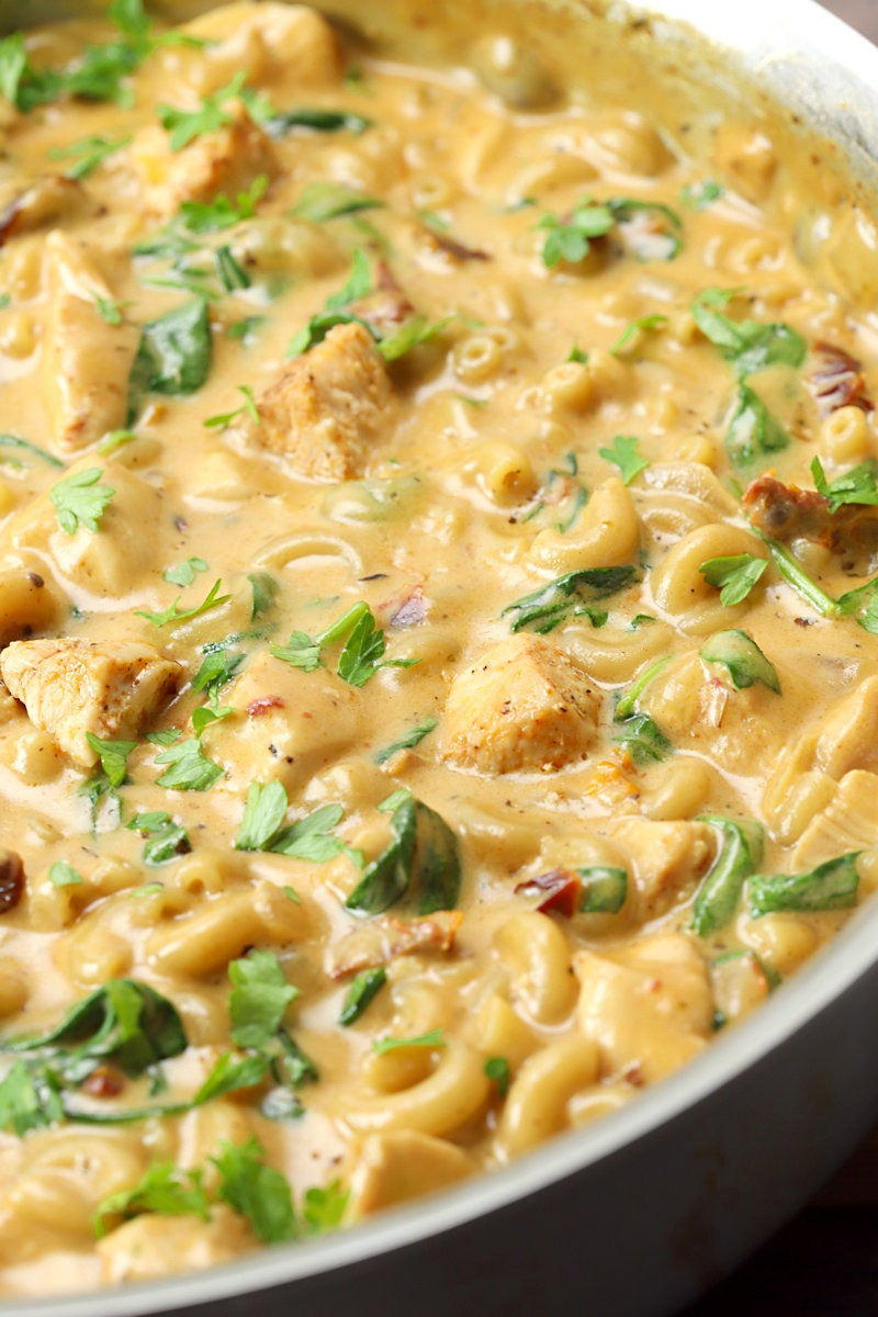 Chicken, spinach, and sun dried tomatoes in macaroni and cheese.