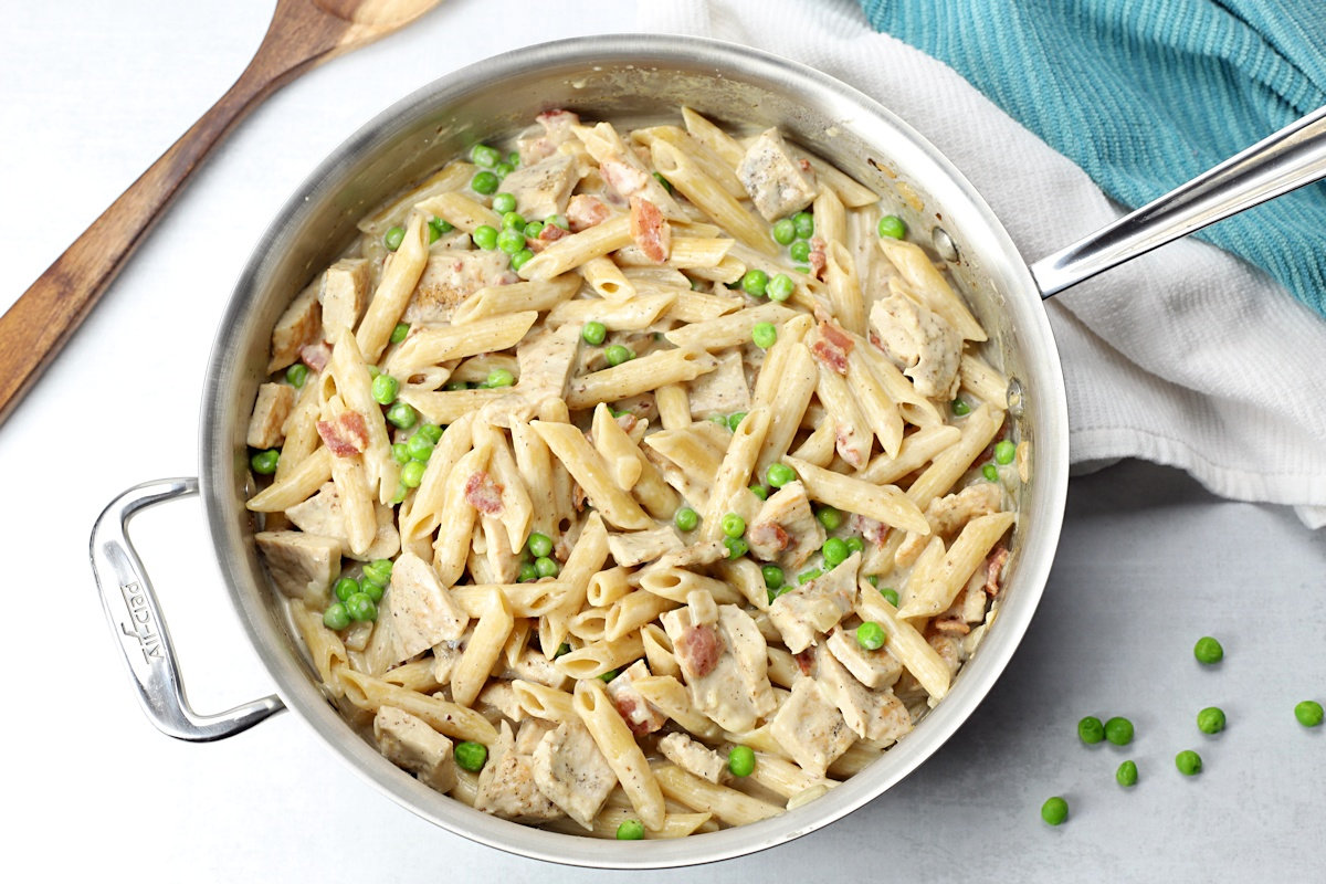 A saute pan filled with leftover turkey alfredo skillet meal.